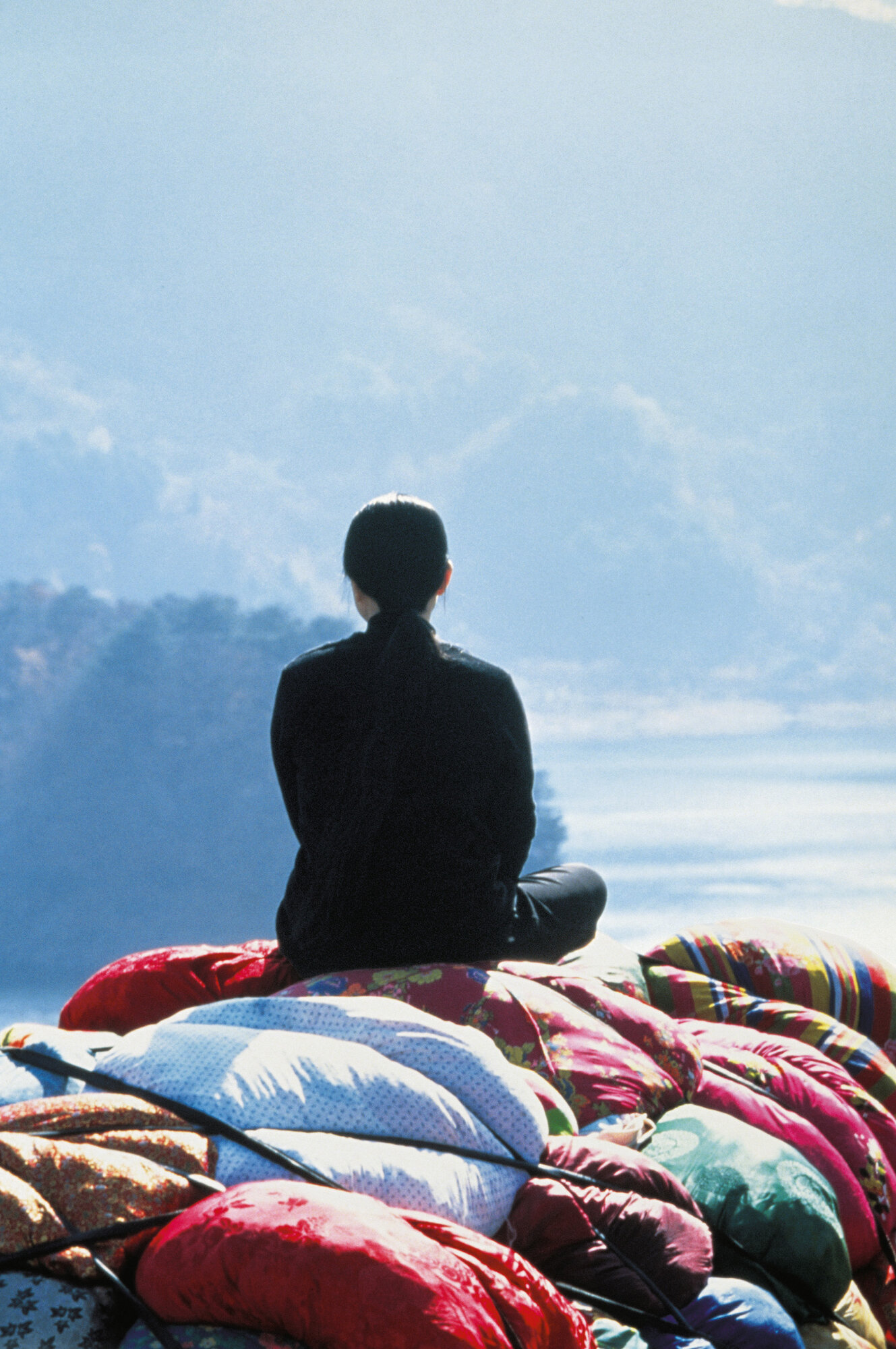 Person from behind on blankets and suitcases