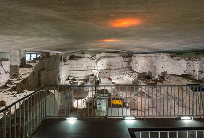 Blick von einer Plattform auf antike Mauern und Gänge im Keller eines Hauses