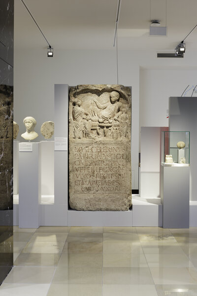 Roman gravestone with a relief image of people and a Latin inscription