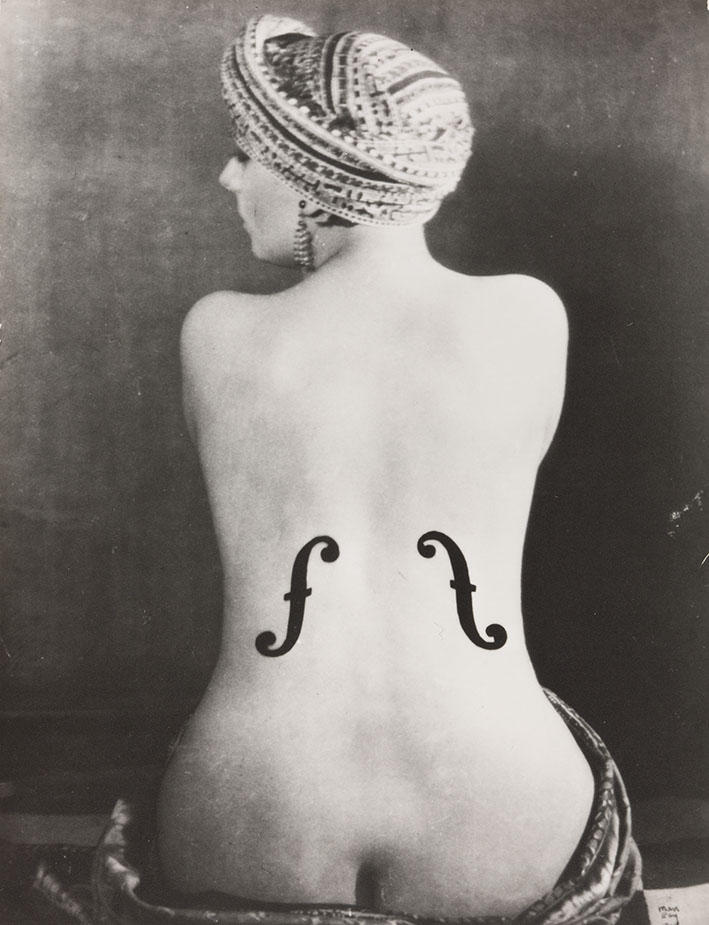 Schwarz-weiß Portrait einer sitzenden Frau von hinten mit zwei Einschnitten ähnlich einer Violine.