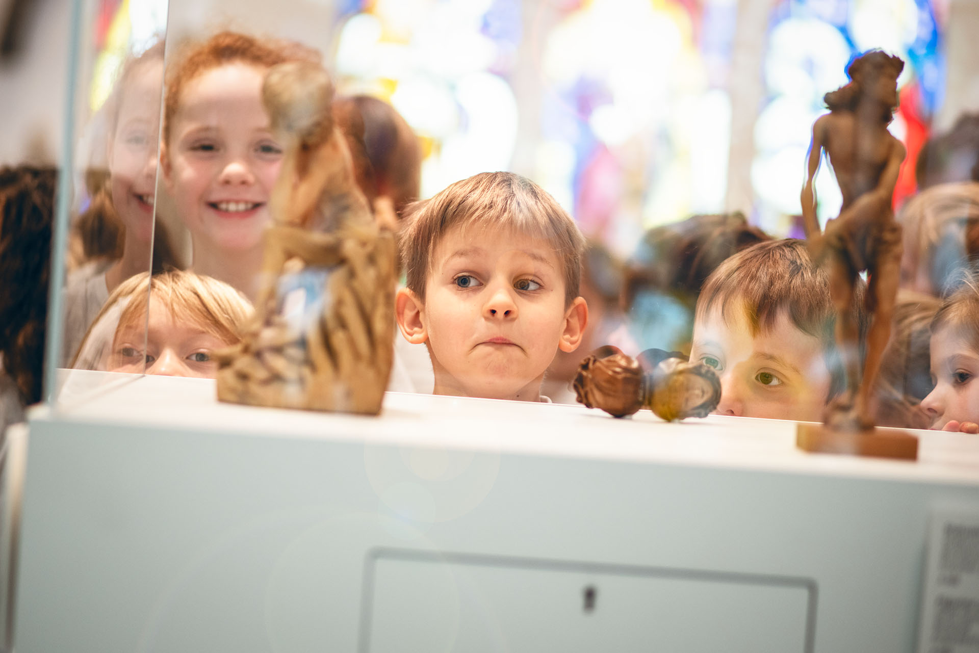 Kinder betrachten das Ausgestellte in einer Vitrine